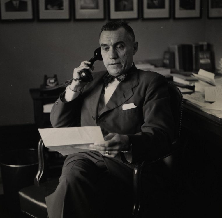 Photograph of Senator Frear on the phone, reading, date unknown