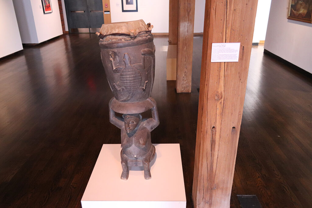 View of carved drum on low pedestal.